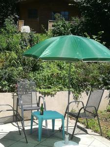 een groene parasol en een tafel en stoelen bij 3072 Apartment MITTERFELD - Top A in Kasten bei Böheimkirchen