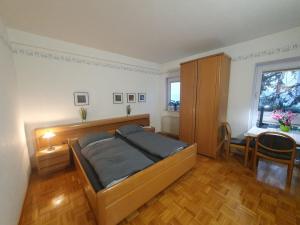 a bedroom with a bed and a table and a window at 17 Apartments und 2 Suiten in Zwingenberg