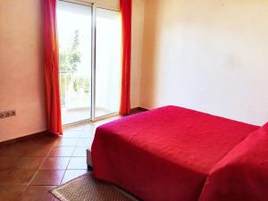a bedroom with a red bed and a large window at Elegant villa in Dar Bouazza with year-round private pool in Dar Bouazza +16 photos