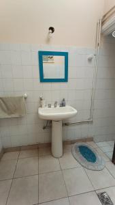 a bathroom with a sink and a blue picture on the wall at Godoy cruz hause in Godoy Cruz