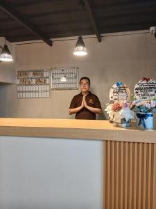 a man standing behind a counter with his hands at Aquila Family Homestay in Lampung