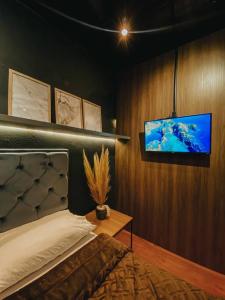 a bedroom with a bed and a flat screen tv at Lux in Igrejinha