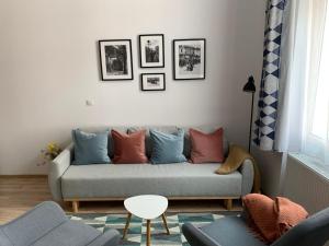 a living room with a gray couch with colorful pillows at Charming Central Apartments in Cluj-Napoca