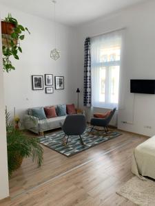 - un salon avec un canapé et une chaise dans l'établissement Charming Central Apartments, à Cluj-Napoca