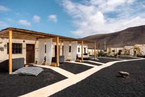 a house in the middle of a desert with a mountain at Finca Luz in Puerto del Rosario