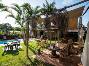 een terras met een tafel en stoelen naast een zwembad bij Pousada Confraria Casa Branca in Casa Branca