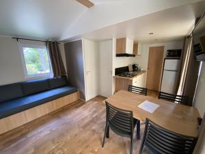salon ze stołem i niebieską kanapą w obiekcie Camping de l'Arnel w mieście Villeneuve-lès-Maguelone