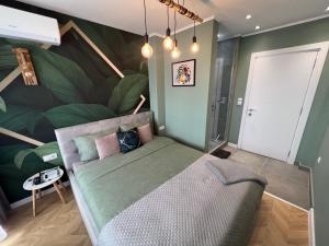1 dormitorio con 1 cama con una gran pared de plantas en Varna Top Center Luxury Apartment, en Varna