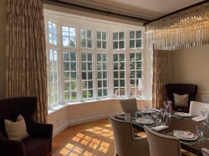 a dining room with a table and a large window at Idyllic Country House in Haslemere in Haslemere
