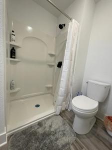 La salle de bains blanche est pourvue d'une douche et de toilettes. dans l'établissement 2 Bedroom Apartment, Walk To Mayo, Free Parking, à Rochester