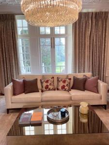 a living room with a couch and a chandelier at Idyllic Country House in Haslemere in Haslemere