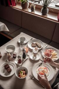 una mesa con platos blancos de comida. en Panorama Hotel Flora en Villandro