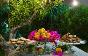 une table avec deux assiettes de nourriture et de fleurs dans l'établissement Casale Romano Resort e Relais, à Motta Camastra