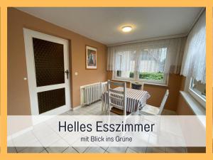 um quarto com uma mesa, uma cadeira e uma janela em Attraktives Ferienhaus im Grünen em Falkensee