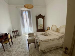 a bedroom with a bed and a mirror and a piano at Il Conte - Villa Gigia in Adelfia