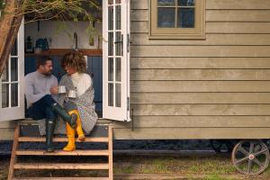 a man and a woman sitting on the porch of a house at Avington Estate in Winchester