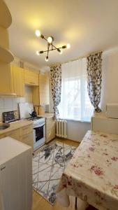 a kitchen with a table and a ceiling fan at Двухкомнатная 19-7 in Atyraū