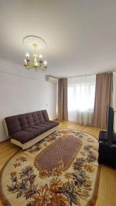 a living room with a couch and a rug at Двухкомнатная 19-7 in Atyraū