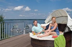 a man and a woman sitting on a deck at Appartment Seeblick 8 2 OG Grundbelegung 4 Pers in Elsterheide