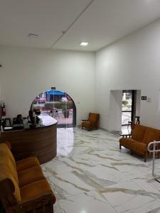 a lobby with a waiting room with chairs and a counter at Hotel Modena - São José dos Campos in São José dos Campos