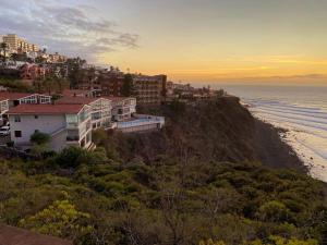 eine Gruppe von Gebäuden auf einem Hügel neben dem Meer in der Unterkunft ¡Vistas al Mar y Lujo en Bajamar! Apto Boutique in Bajamar