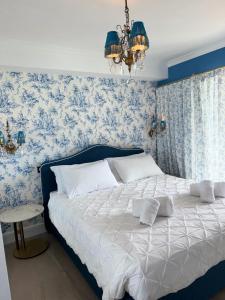 una camera da letto con un letto con carta da parati blu di Annabel's Suite Apartament a Roquebrune-Cap-Martin