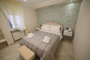 1 dormitorio con 1 cama con 2 toallas en L'OASI DA ROSY, en Martina Franca
