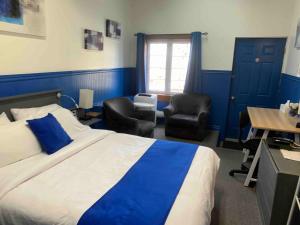 1 dormitorio con 1 cama, 2 sillas y escritorio en Motel Magistral en St-Raphael-de-Bellechasse
