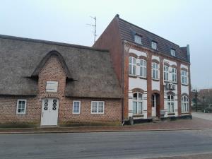 un ancien bâtiment en briques avec un toit gris dans l'établissement Apartment mit Balkon im Herzen von Høyer, à Højer