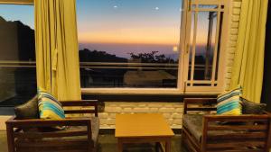 uma sala de estar com uma grande janela com vista em Great Empire Hotel em Dharamshala