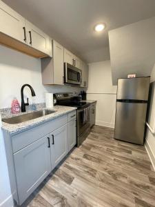 a kitchen with white cabinets and a stainless steel refrigerator at Heart of Downtown Free Parking Walk to Mayo in Rochester