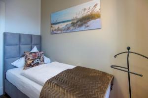 a bedroom with a bed and a picture on the wall at FeWo Lina in Borkum +5 photos