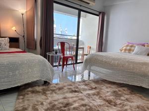 a bedroom with two beds and a table with a view at Cozy 1br walk to BTS and Airport Rail Link Close to Malls M11 in Bangkok