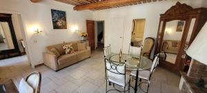a living room with a glass table and a couch at Appartements de charme La Sarrazine in La Garde-Freinet