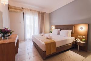 a hotel room with a large bed and a desk at Tosca Beach Hotel in Paleo Tsifliki