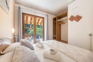 a large white bed in a room with a window at Residence Tatiana A4 in Tremosine Sul Garda