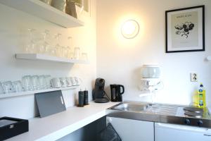 cocina con fregadero y encimera con gafas en City Apartment in bester Lage, en Wolfsburg