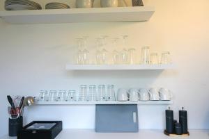 een plank gevuld met glazen vazen op een muur bij City Apartment in bester Lage in Wolfsburg