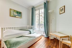 a bedroom with a bed and a window at Appartement charmant Quartier culturel in Paris