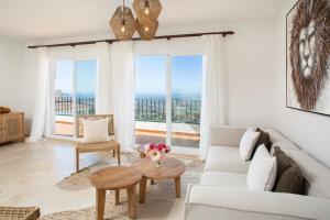 uma sala de estar com um sofá e uma mesa em Charming penthouse with sea views in Mijas pueblo em Mijas