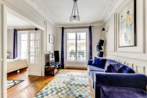a living room with a blue couch and a rug at Appartement charmant Quartier culturel in Paris