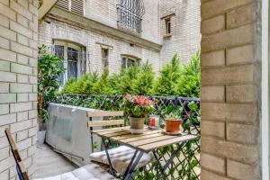 a wooden table with flowers on a balcony at Appartement charmant Quartier culturel in Paris