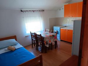 a kitchen with a table and chairs in a room at Apartmani Ivan in Gornji Karin