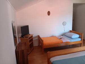 a small bedroom with a bed and a television at Apartmani Ivan in Gornji Karin