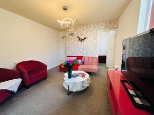 a living room with red furniture and a red couch at Luminous Suites in Blackpool