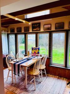 a dining room with a table with chairs and windows at Altja Villa-privaatne saunaga puhkemaja Lahemaa Rahvuspargis in Altja
