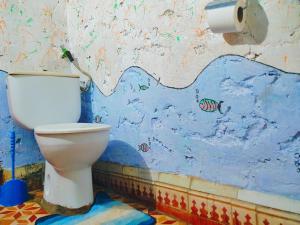 a bathroom with a toilet in a blue wall at l'expérience Berbère in Agadir