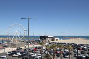 um parque de estacionamento com uma roda gigante e uma praia em appartement 2 pieces avec parking et vue sur la marina em Canet-en-Roussillon