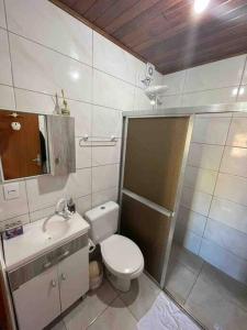 a small bathroom with a toilet and a sink at Toca da Garoupa in Laguna