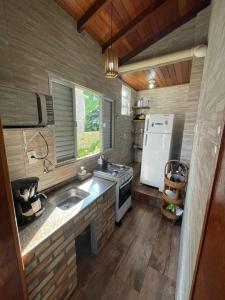 a small kitchen with a sink and a refrigerator at Toca da Garoupa in Laguna